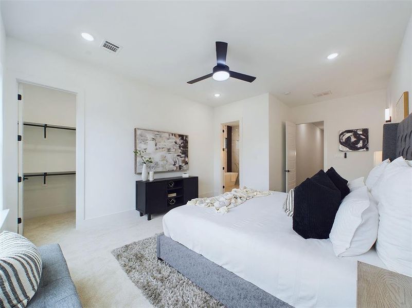 Corner view of the primary bedroom with access to the first closet and the primary bathroom.