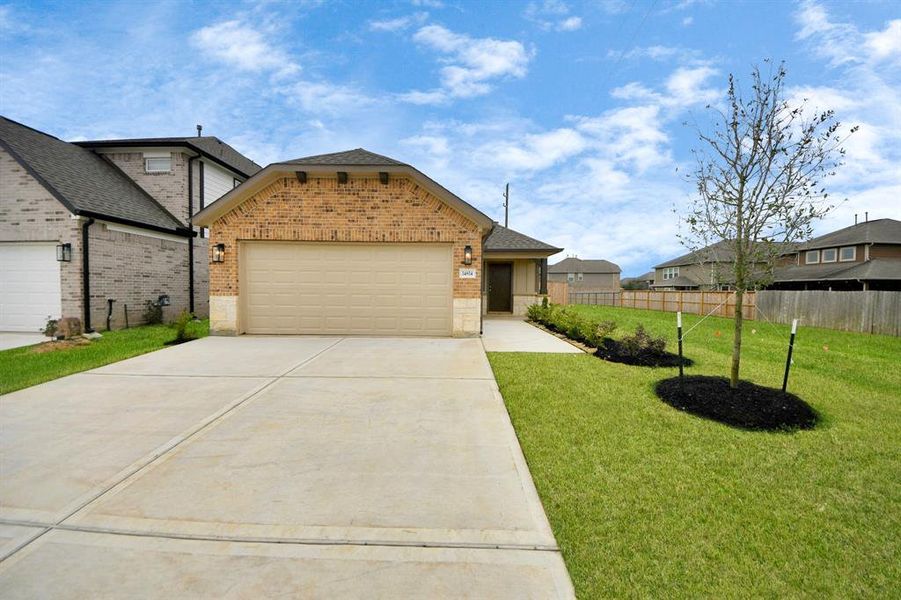 Meticulously maintained yard and lush landscape, paired with a premium elevation featuring captivating brick accents. Modern coach lights add a touch of contemporary elegance to the exterior.