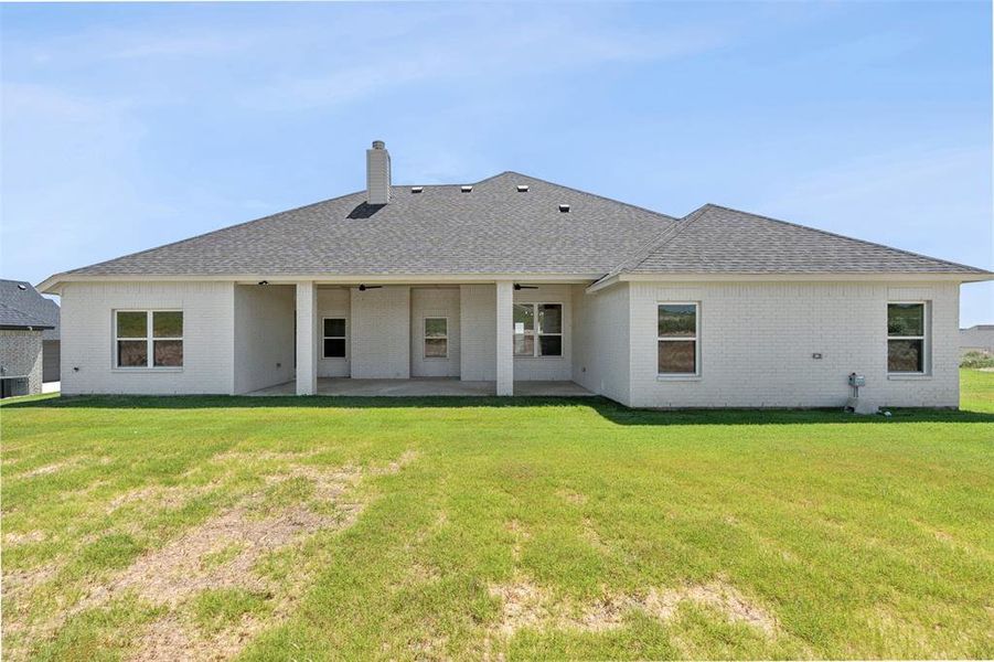 Rear view of property with a patio and a lawn