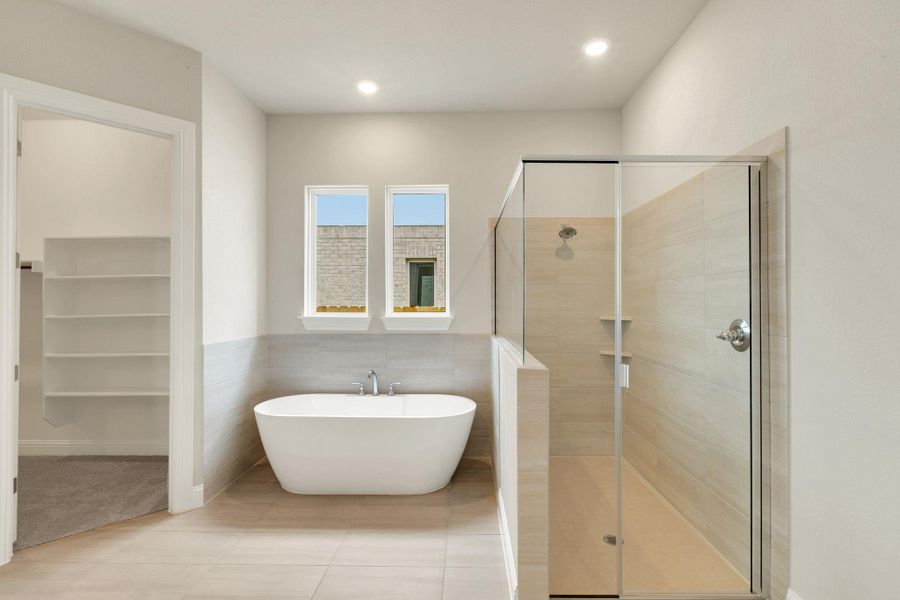 Bathroom with a shower stall, recessed lighting, tile walls, and a soaking tub Bathroom with a shower stall, recessed lighting, tile walls, and a soaking tub