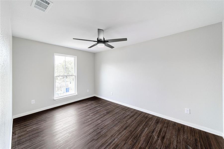 Unfurnished room with dark wood-style flooring and ceiling fan
