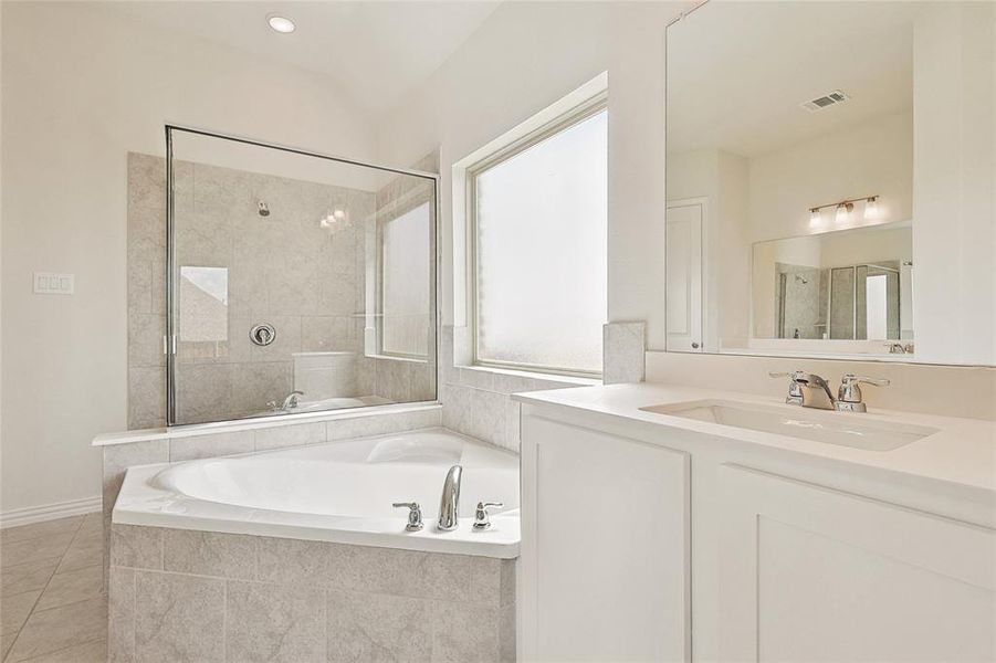 Bathroom featuring independent shower and bath, vanity, and tile patterned flooring