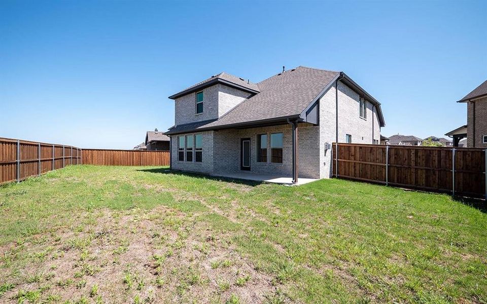 Back of house with a lawn and a patio area
