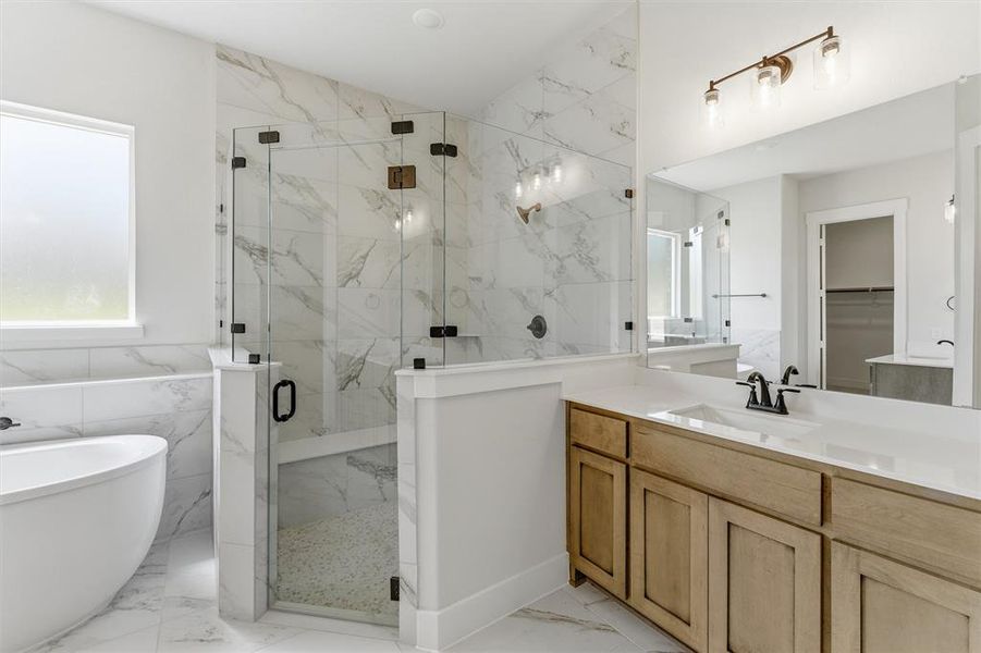 Full bathroom featuring a marble finish shower, a soaking tub, light marble finish flooring, vanity, and tile walls