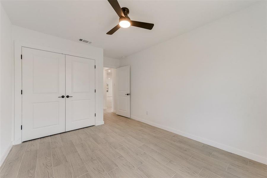 Unfurnished bedroom featuring ceiling fan and a closet