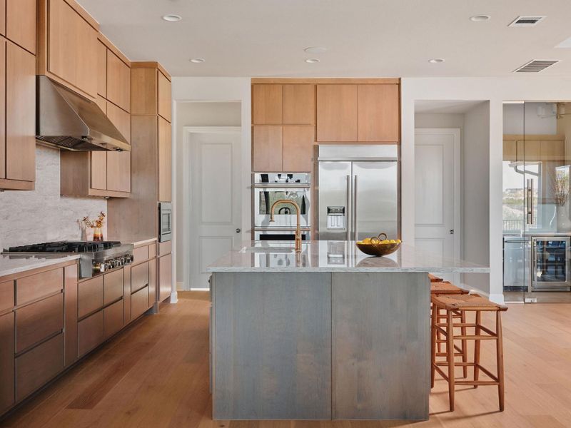 The kitchen is equipped with upgraded JennAir appliances, including a 48-inch gas cooktop with griddle and professional vent hood.