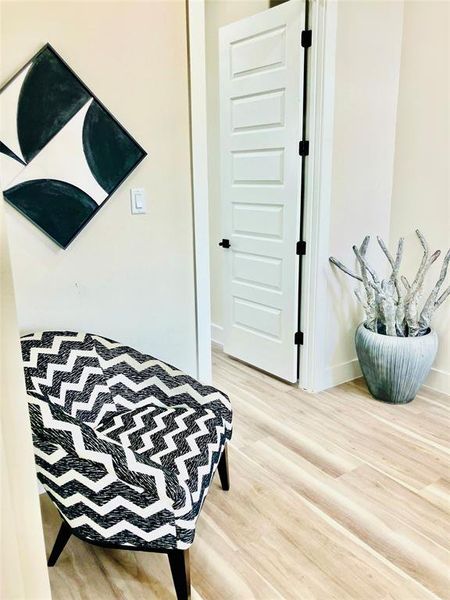 Cozy reading alcove with elegant hardwood floors and serene wall art, perfect for unwinding with your favorite book.