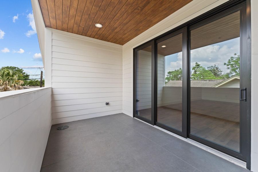 A wood-paneled ceiling and outdoor fans create a year-round perch for sunsets and slow mornings.