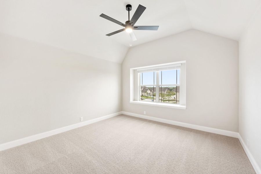 Empty bedroom with vaulted ceiling, ceiling fan, carpet flooring, and large window with neighborhood view