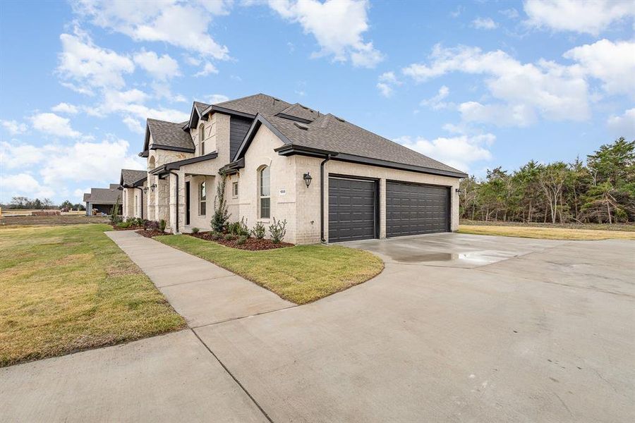 View of side of property with a lawn and a garage