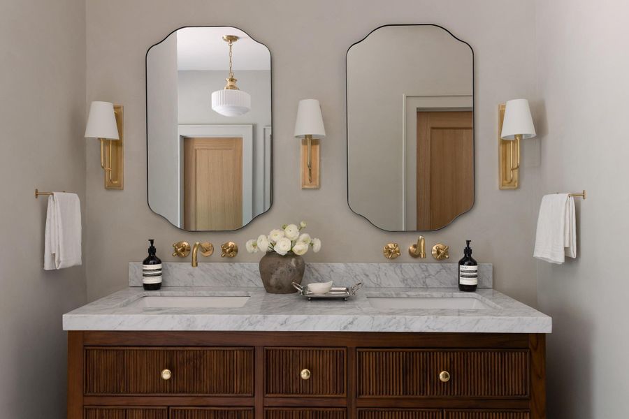 Primary bath has Dual vanity featuring a marble countertop with integrated sinks and unlacquered brass plumbing fixtures Primary bath has Dual vanity featuring a marble countertop with integrated sinks and unlacquered brass plumbing fixtures