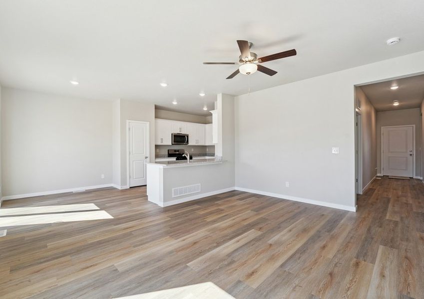 The family room is spacious with a ceiling fan and plank flooring. The family room is spacious with a ceiling fan and plank flooring.