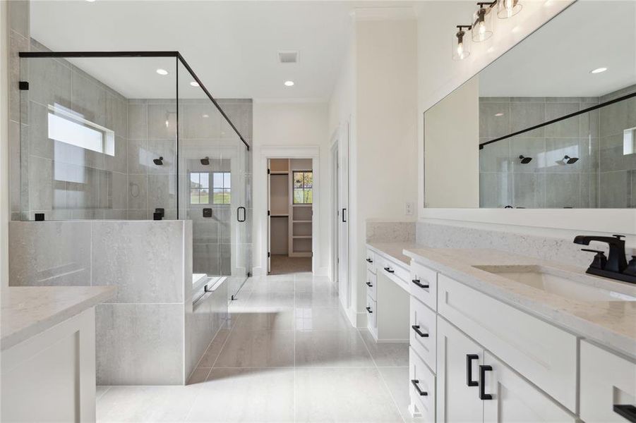 Bathroom featuring tile patterned flooring, vanity, a shower with shower door, and a healthy amount of sunlight