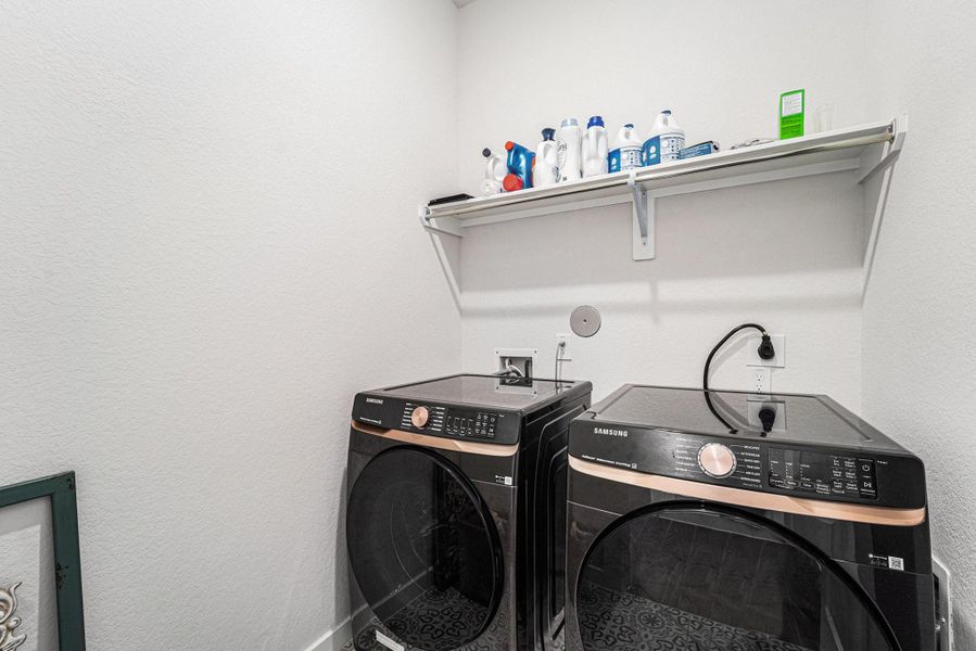 Dedicated laundry space with Samsung washer/dryer and storage shelf.