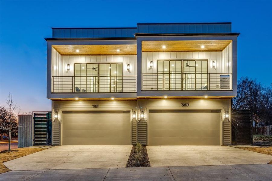 Contemporary house featuring board and batten siding, driveway, a balcony, and an attached garage