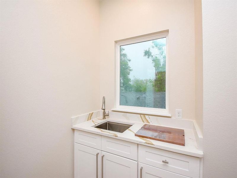 Laundry room located between master and secondary bedrooms includes full sink, storage, and built in shelving.