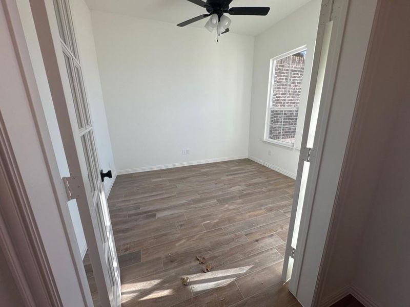 Unfurnished room with dark wood finished floors and a ceiling fan Unfurnished room with dark wood finished floors and a ceiling fan