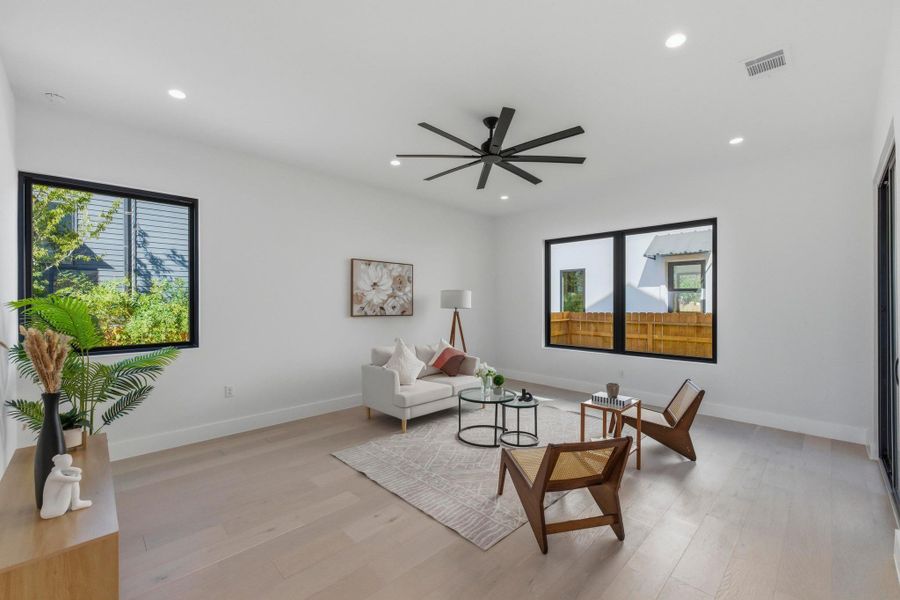 Living area with light wood-style floors, recessed lighting, and a ceiling fan