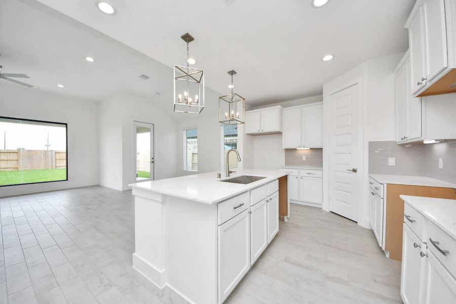 This kitchen is by far any chef’s dream! This spacious kitchen features high ceilings, light stained wood cabinets, granite countertop, SS appliances, modern tile backsplash, recessed lighting, extended counter space, granite kitchen island with double sink, and space for breakfast bar, and a walk-in pantry all overlooking your huge family room.