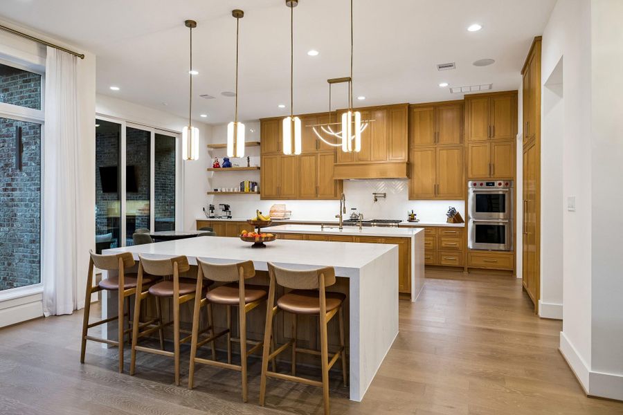 The double-island kitchen features top-of-the-line appliances from Wolf, JennAir, and Sub-Zero.