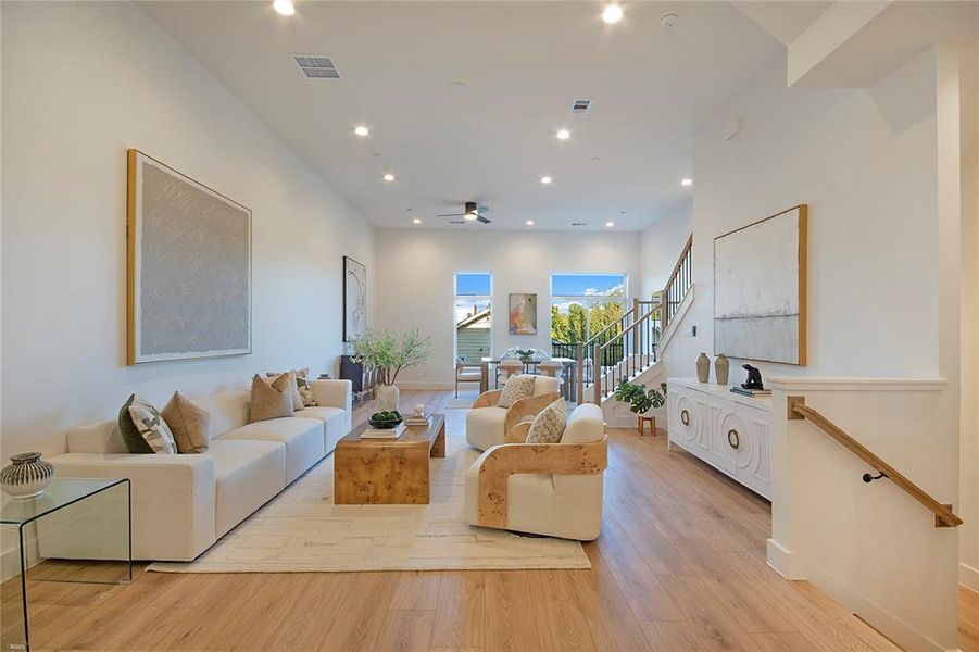 Living area featuring recessed lighting, light wood finished floors, stairway, and ceiling fan Living area featuring recessed lighting, light wood finished floors, stairway, and ceiling fan