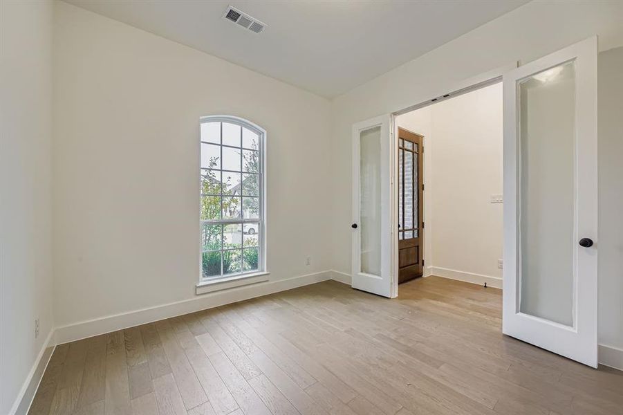 Empty room featuring light wood-type flooring and french doors