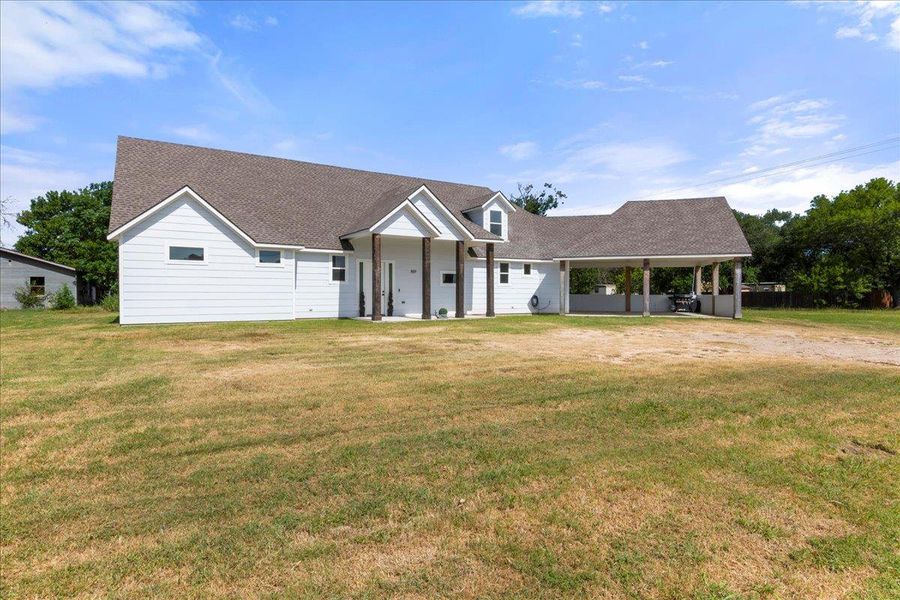 View of front of home featuring a shingled roof and a front lawn View of front of home featuring a shingled roof and a front lawn