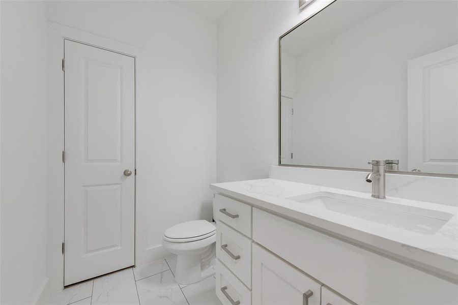 Bathroom featuring vanity and light marble finish floors Bathroom featuring vanity and light marble finish floors