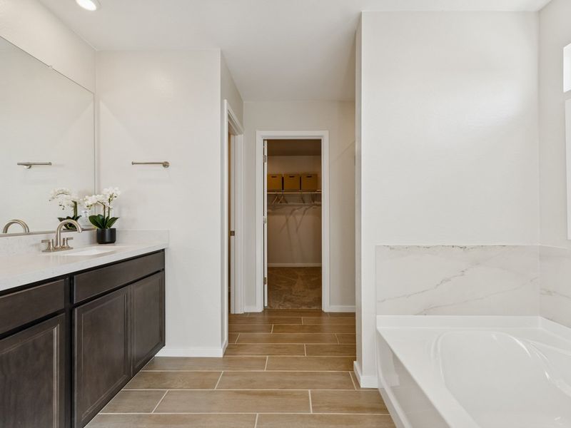 A bathroom with a tub and sink. A bathroom with a tub and sink.