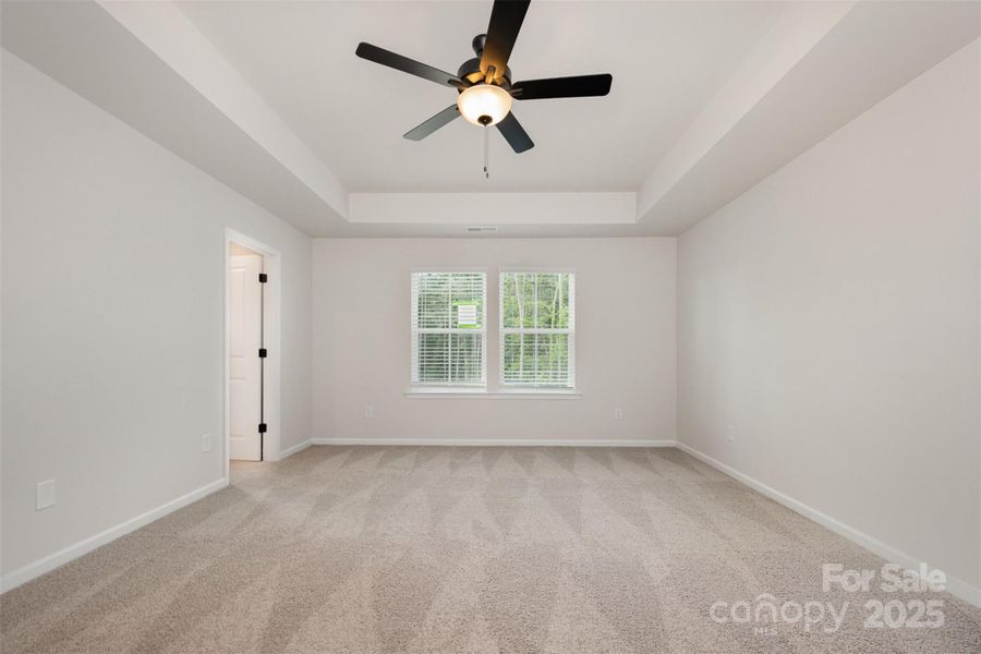 Primary bedroom w/ ceiling fan. Representational Photo.