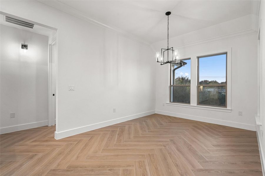 Unfurnished dining area featuring a chandelier and ornamental molding