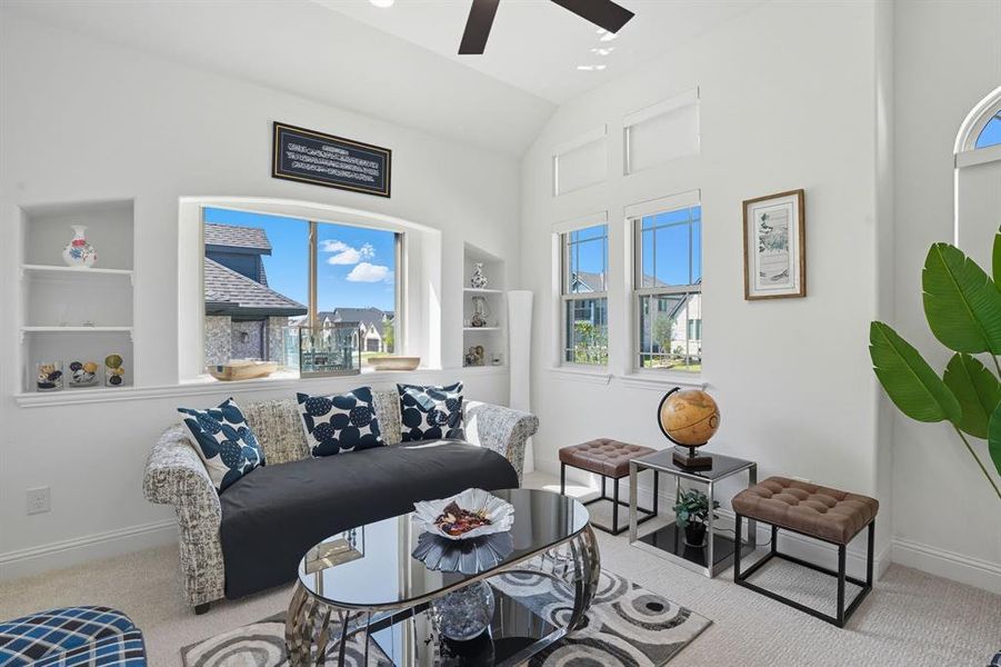 Living room featuring carpet flooring, a ceiling fan, and lofted ceiling