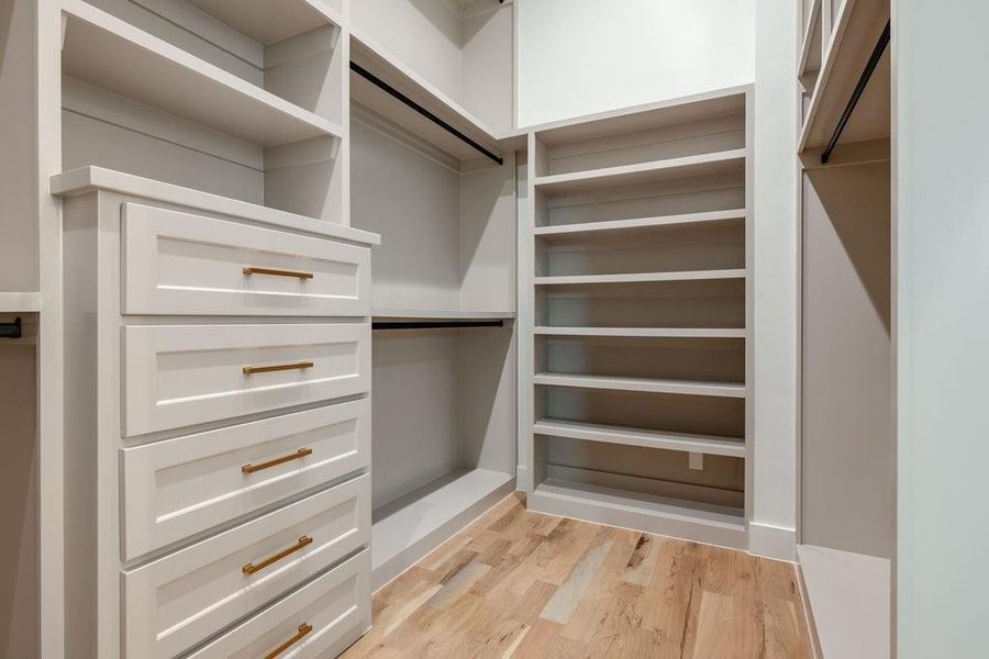 Walk in closet with built in cabinets and shoe racks. Two separate closets