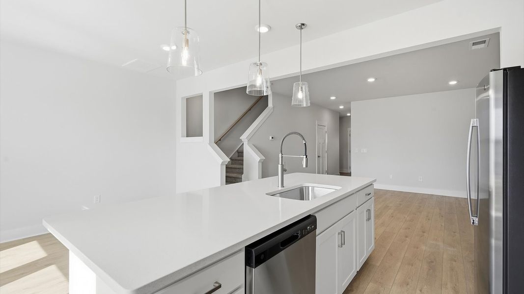 Tasteful design meets functional luxury in this kitchen with a center island and modern pendant lighting