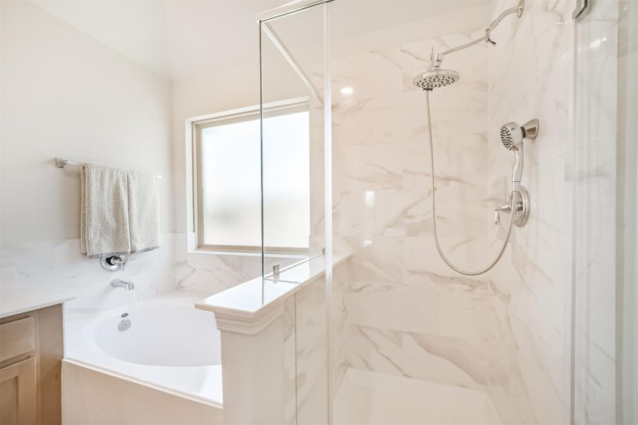 A closer look at the walk in shower and soaking tub showcases the level of detail throughout. The walk in shower features gorgeous frameless glass with a marbled tile surround and chrome finishes, while the soaking tub offers the perfect place to relax after a long day. A closer look at the walk in shower and soaking tub showcases the level of detail throughout. The walk in shower features gorgeous frameless glass with a marbled tile surround and chrome finishes, while the soaking tub offers the perfect place to relax after a long day.