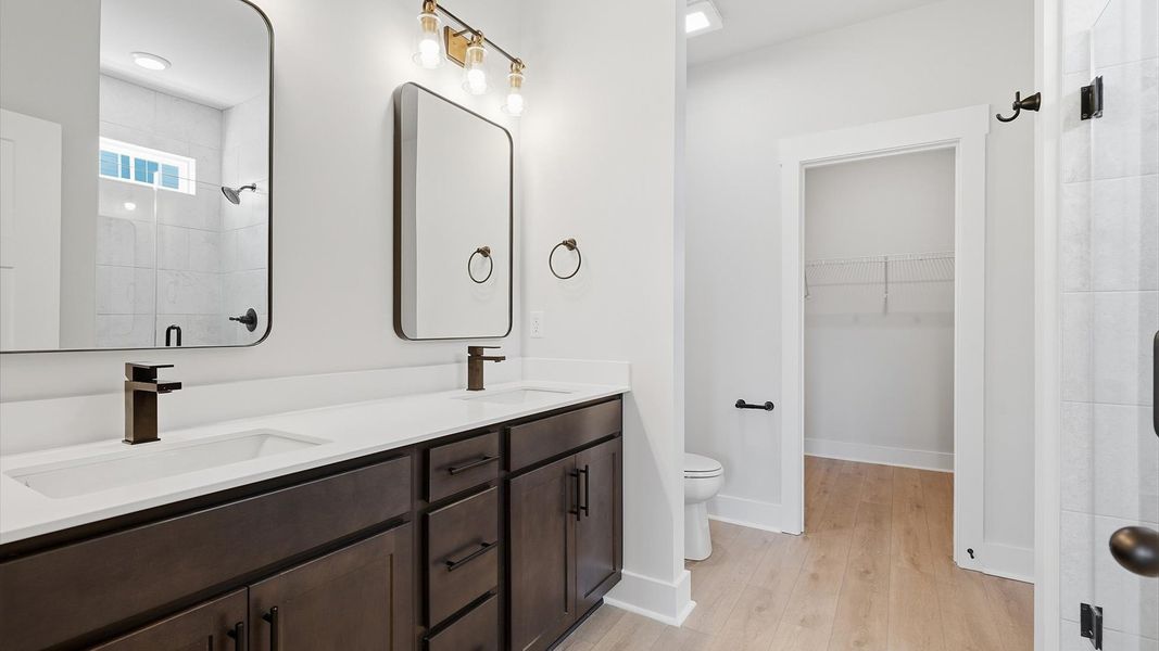Superior en-suite primary bathroom with stylish dual vanity and walk-in shower—crafted with high standards in mind