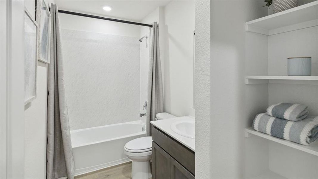 Bathroom with vanity, shower / tub combo with curtain, light wood-style flooring, and recessed lighting Bathroom with vanity, shower / tub combo with curtain, light wood-style flooring, and recessed lighting