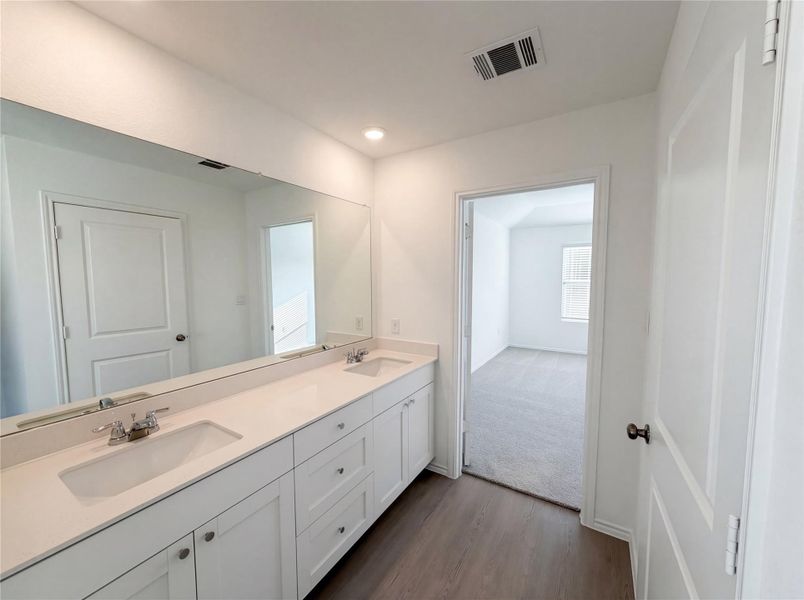 Full bath featuring double vanity, dark wood-style floors, and recessed lighting