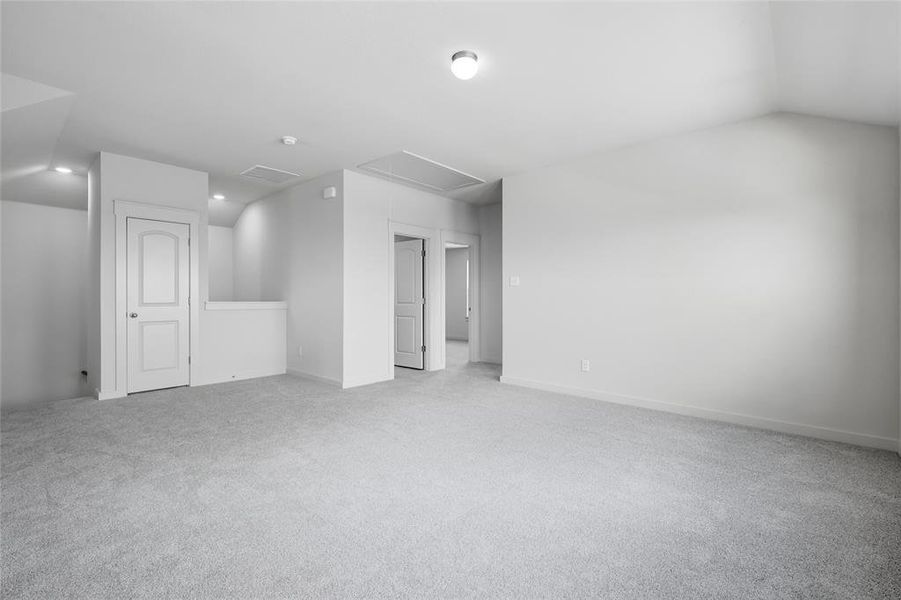 Bonus room with attic access and light colored carpet Bonus room with attic access and light colored carpet
