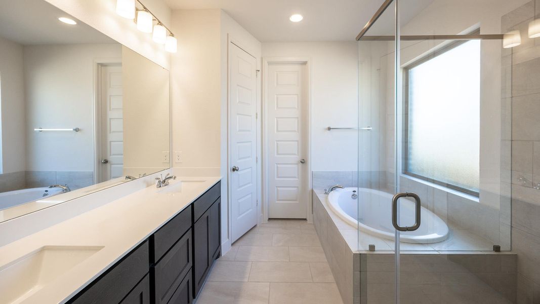 Bathroom with a bath, double vanity, recessed lighting, a stall shower, and light tile patterned flooring Bathroom with a bath, double vanity, recessed lighting, a stall shower, and light tile patterned flooring