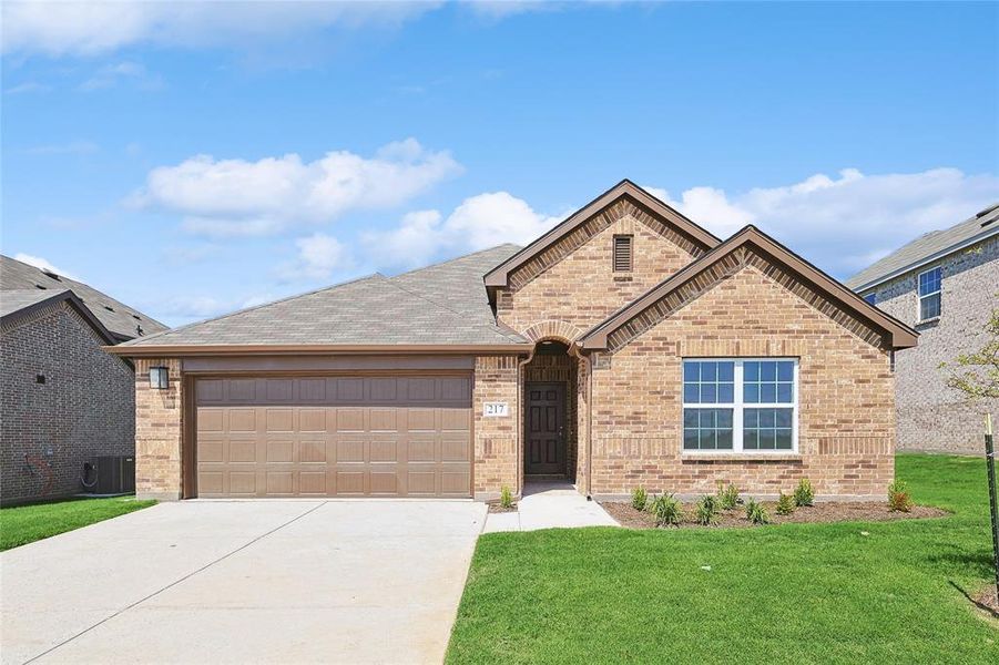 View of front facade featuring a garage and a front lawn