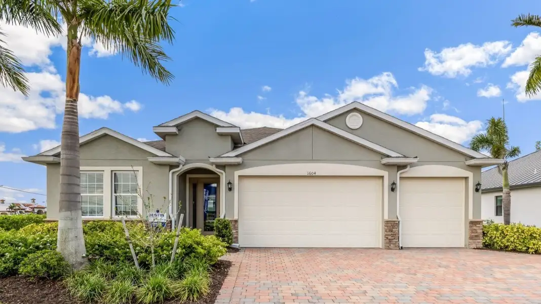 Front exterior of a new home in Cape Coral Spot - Tradition, Cape Coral, FL, highlighting curb appeal (Image 1). Front exterior of a new home in Cape Coral Spot - Tradition, Cape Coral, FL, highlighting curb appeal (Image 1).