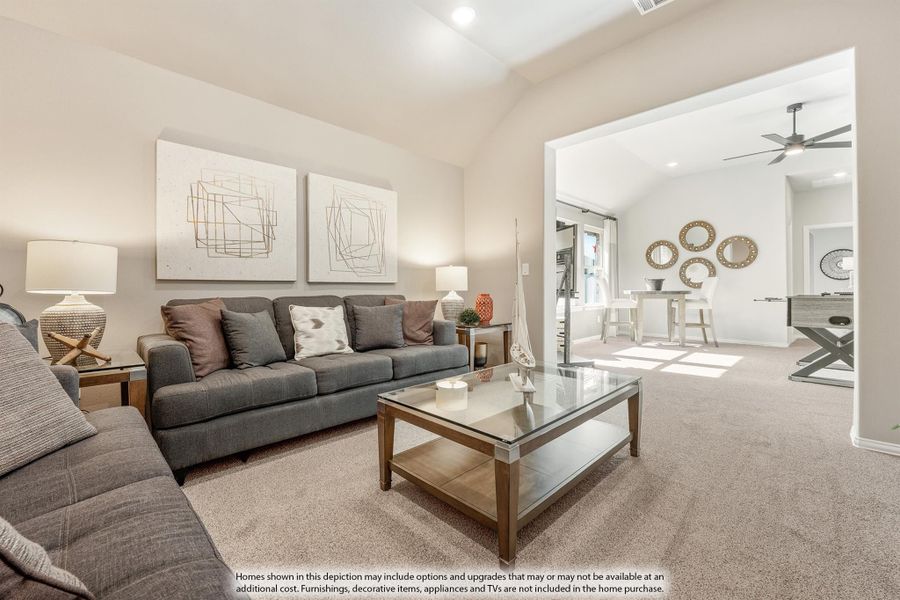 Living room with gray sofa, glass coffee table, vaulted ceiling, and open view into dining and game room areas Living room with gray sofa, glass coffee table, vaulted ceiling, and open view into dining and game room areas