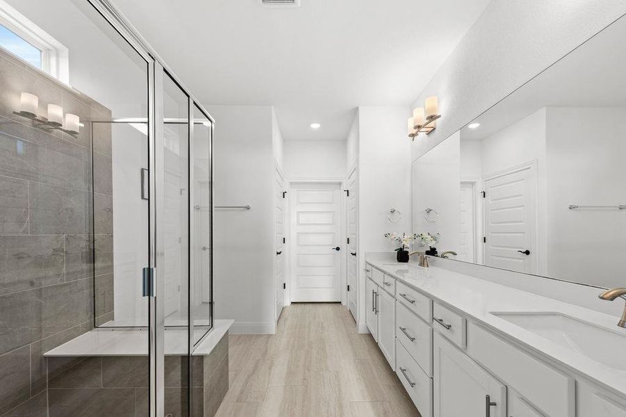Primary bathroom facing the water closet, primary walk-in closet, and linen closet.