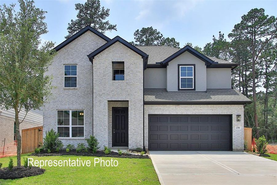View of front of property with driveway, an attached garage, a shingled roof, and stucco siding