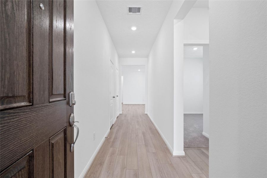 Step inside your new home, where the Bandera vinyl plank flooring in French Oak and fresh, bright paint create a warm and inviting entryway.