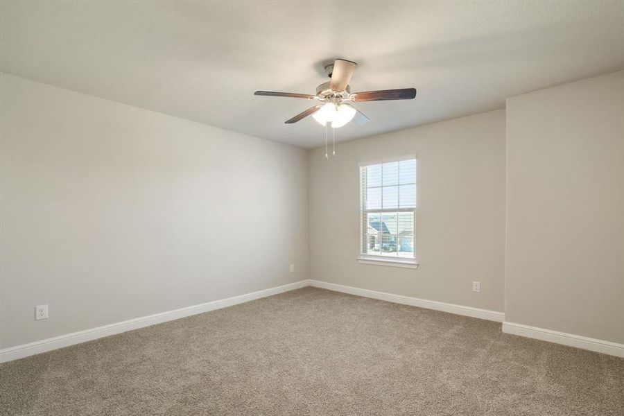 Carpeted spare room with baseboards and ceiling fan Carpeted spare room with baseboards and ceiling fan
