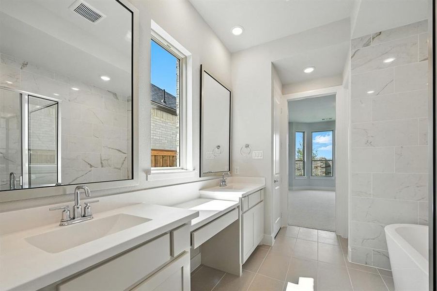 Bathroom with plenty of natural light, a soaking tub, double vanity, light tile patterned flooring, and recessed lighting Bathroom with plenty of natural light, a soaking tub, double vanity, light tile patterned flooring, and recessed lighting