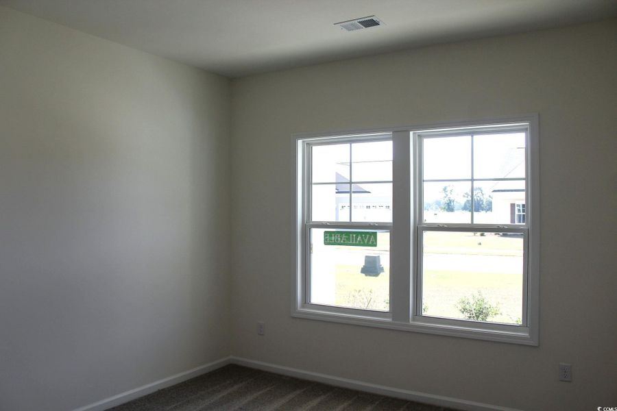 Unfurnished room featuring baseboards and dark colored carpet