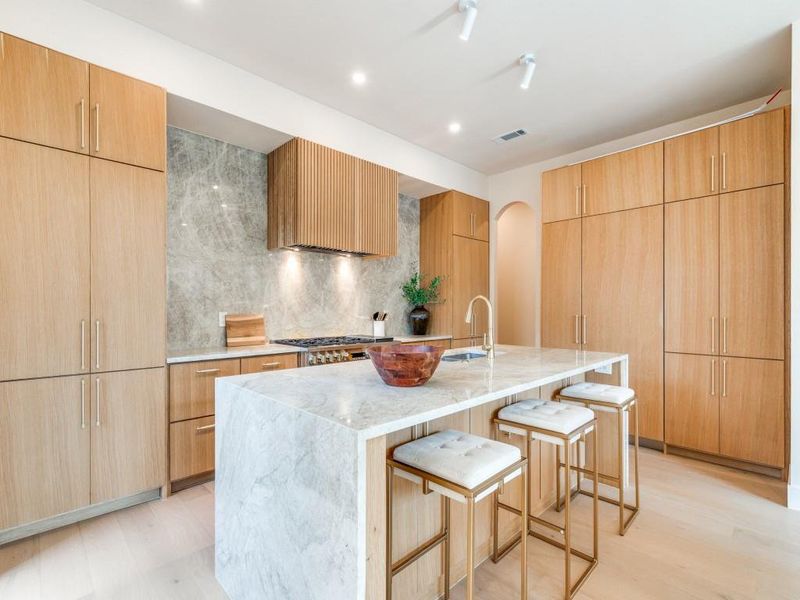 Contemporary kitchen with Designer Cabinets and waterfall edge counters Contemporary kitchen with Designer Cabinets and waterfall edge counters